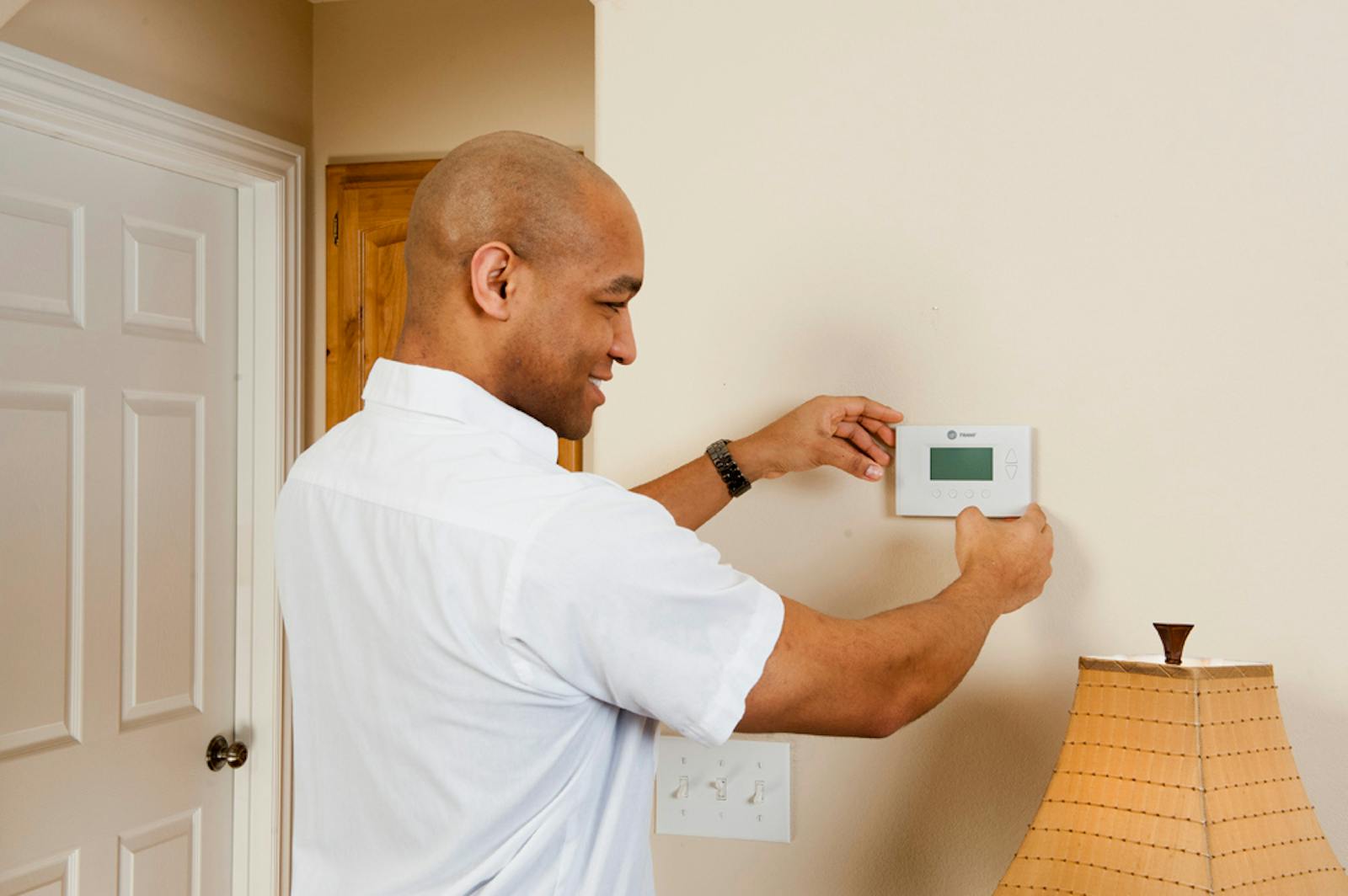 Technician installing a smart thermostat during a building automation project